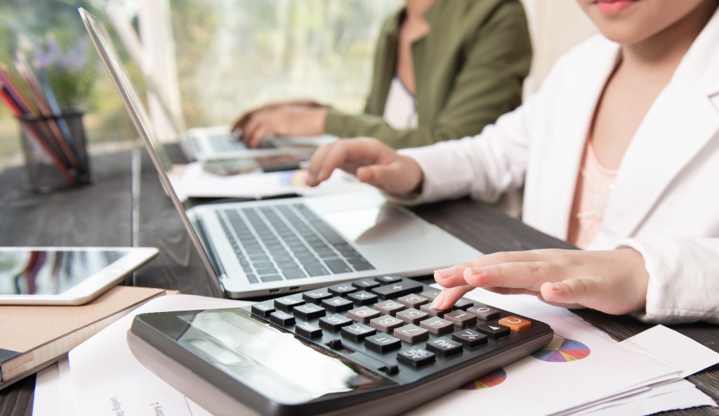Accountants working with financial reports and calculator